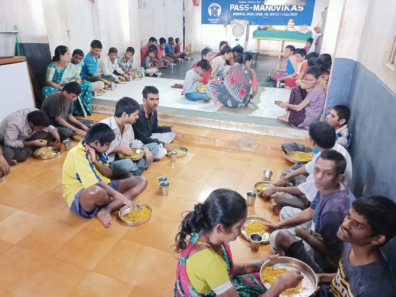 Two children with hands folded before their meal trays